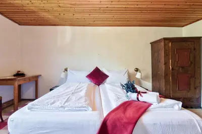 a bedroom with two beds with white sheets and a wooden ceiling at Privatzimmervermietung Messner in Rifiano
