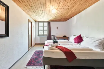 a bedroom with two beds and a wooden ceiling at Privatzimmervermietung Messner in Rifiano