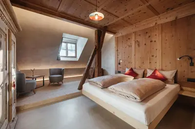 a bedroom with a bed in a room with wooden walls at Lüch Colz in Badia