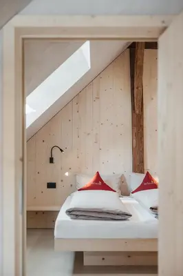 a bedroom with a white bed with red pillows at Lüch Colz in Badia