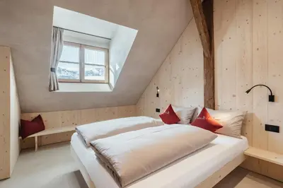 a bedroom with a white bed with red pillows at Lüch Colz in Badia
