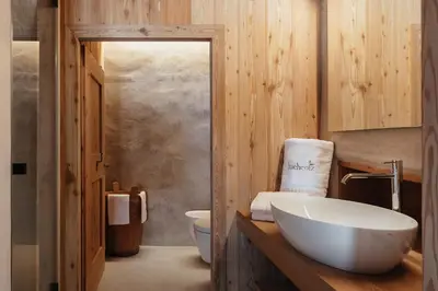 a bathroom with a white bowl sink in a wooden bathroom at Lüch Colz in Badia