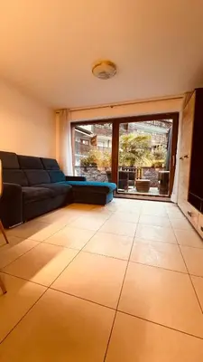 a living room with a couch and a large window at Appartement Alois in Bressanone