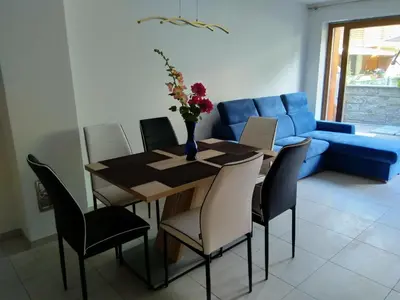 a dining room table with chairs and a blue couch at Appartement Alois in Bressanone