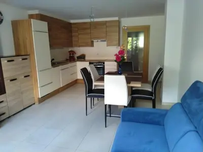 a kitchen with a blue couch and a table and chairs at Appartement Alois in Bressanone