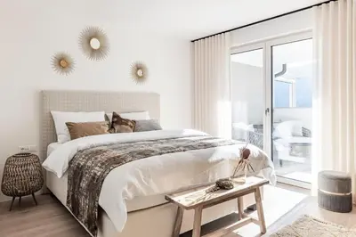 a white bedroom with a large bed and a window at Romy & Johannes Guesthouse in Schenna
