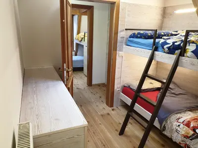 a room with two bunk beds and a desk at Ampio appartamento su 2 livelli con garage coperto in Valdaora