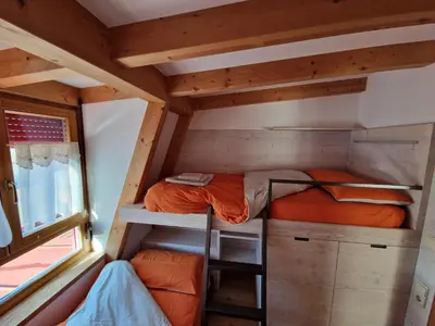 a bedroom with a bunk bed in a tiny house at Ampio appartamento su 2 livelli con garage coperto in Valdaora