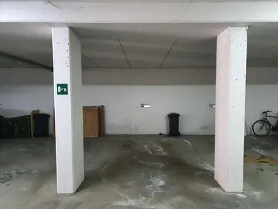 an empty parking garage with a bike parked in it at Ampio appartamento su 2 livelli con garage coperto in Valdaora