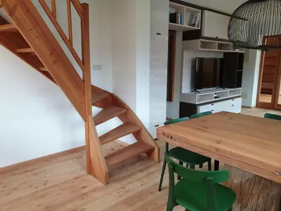 a small room with a wooden table and a staircase at Ampio appartamento su 2 livelli con garage coperto in Valdaora