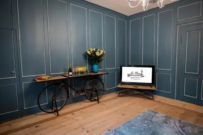 a room with blue walls with a bike and a television at La Cles Deluxe Suites in Cles