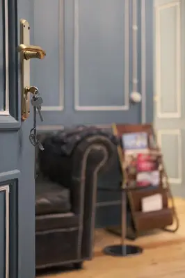 a living room with a leather chair and a table at La Cles Deluxe Suites in Cles