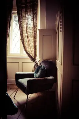 a couch sitting in a room with a window at La Cles Deluxe Suites in Cles
