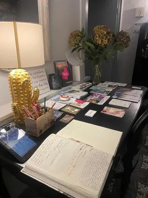a desk with an open book and a lamp at La Cles Deluxe Suites in Cles