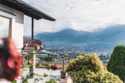 a view of a city from a balcony of a house at Der Ruibacher in Marlengo