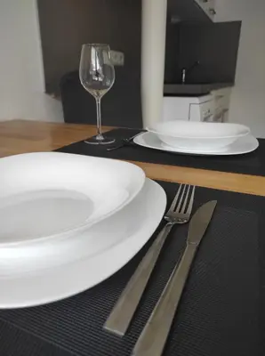a table with two white plates and a wine glass at Ferienwohnungen Pircher in Rablà
