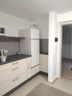 a kitchen with white cabinets and a white refrigerator at Ferienwohnungen Pircher in Rablà