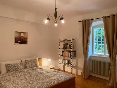 a bedroom with a bed and a book shelf at Cozy Apartment in a Historic Villa in Merano
