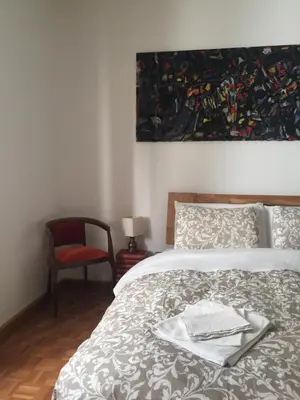 a bedroom with a bed and a book shelf at Cozy Apartment in a Historic Villa in Merano