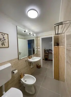 a bathroom with two toilets and a sink and a mirror at Cozy Apartment in a Historic Villa in Merano