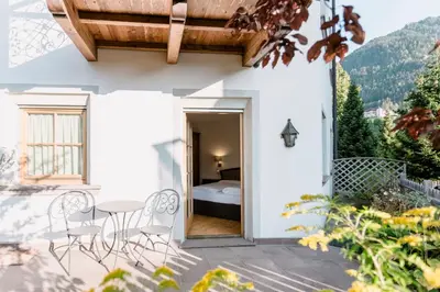 a patio with a table and chairs and a bed at Residence Castel in Ortisei