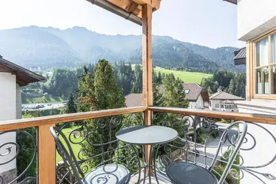a balcony with a table and chairs and mountains at Residence Castel in Ortisei