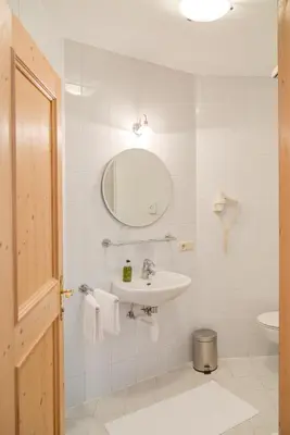 a bathroom with a sink and a mirror and a toilet at Gasthof Wunder in Auna di Sotto
