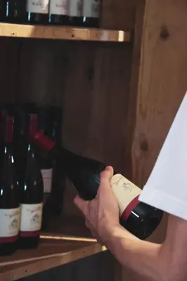 a person is pouring a bottle of wine at Gasthof Wunder in Auna di Sotto
