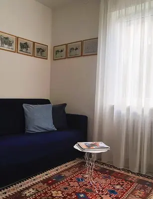 a living room with a blue couch and a window at Appartamento Nadia, bilocale nel verde a 5 minuti dal centro in Merano
