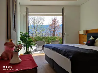 a bedroom with a bed and a large window at Ruhige Ferienwohnung mit Garten und Garage in Privatvilla in Marlengo