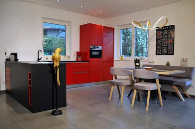 a kitchen with red cabinets and a bird on a counter at Ruhige Ferienwohnung mit Garten und Garage in Privatvilla in Marlengo