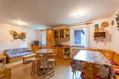 a kitchen and living room with a table and chairs at Residence Sas de le Undesc in Soraga