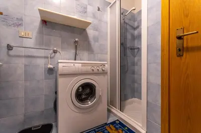 a washing machine in a bathroom with a shower at Residence Sas de le Undesc in Soraga