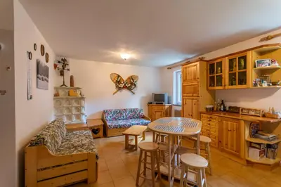 a kitchen and living room with a table and chairs at Residence Sas de le Undesc in Soraga