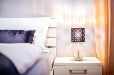 a bedroom with a bed and a lamp on a night stand at Laube35 Central City Apartments in Vipiteno