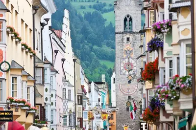 a city street with buildings and a clock tower at Laube35 Central City Apartments in Vipiteno