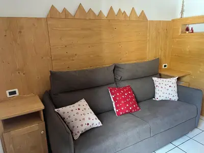 a couch with pillows on it in a room at CIASA SORES in Moena