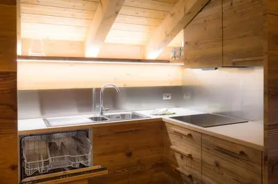 a kitchen with wooden cabinets and a sink at Pigala Al Drit in Rivamonte