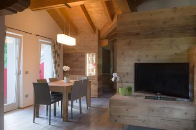 a dining room with a table and a flat screen tv at Pigala Al Drit in Rivamonte