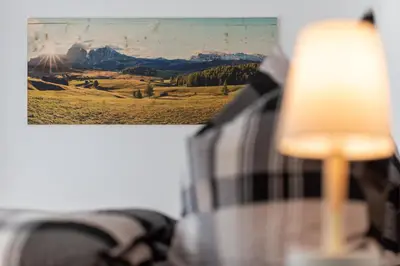 a lamp sitting on a table next to a picture at Luxury Chalet Trumpfer in Riscone