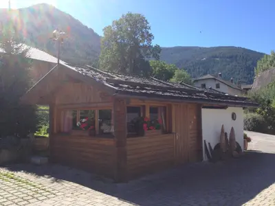 a small wooden building with a mountain in the background at Residence Untermoarhof in Brunico