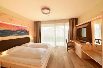 a bedroom with a bed and a television in it at MONTARA living mountain air in Terento