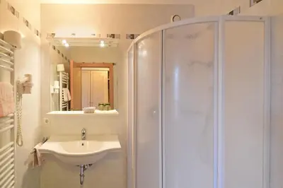 a white bathroom with a sink and a shower at MONTARA living mountain air in Terento