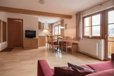 a living room with a table and chairs and a kitchen at Obereggerhof - Urlaub auf dem Bauernhof - Ferienwohnungen - Gitschberg Jochtal - Rio di Pusteria in Valles
