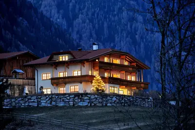 a large house with a christmas tree in front of it at Obereggerhof - Urlaub auf dem Bauernhof - Ferienwohnungen - Gitschberg Jochtal - Rio di Pusteria in Valles