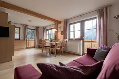 a living room with a purple couch and a table at Obereggerhof - Urlaub auf dem Bauernhof - Ferienwohnungen - Gitschberg Jochtal - Rio di Pusteria in Valles