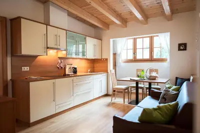 a kitchen and living room with a couch and a table at Obereggerhof - Urlaub auf dem Bauernhof - Ferienwohnungen - Gitschberg Jochtal - Rio di Pusteria in Valles