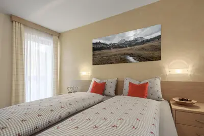 a bedroom with a bed with red pillows at DACIASA Apartment in San Vigilio Di Marebbe