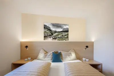 a bedroom with two beds and a painting on the wall at DACIASA Apartment in San Vigilio Di Marebbe