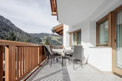 a balcony with a table and chairs on it at DACIASA Apartment in San Vigilio Di Marebbe